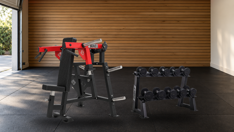 BUILT Strength OG Series Seated Shoulder Press next to a Foundation Series dumbbell rack in a garage home gym with an oak slat wall