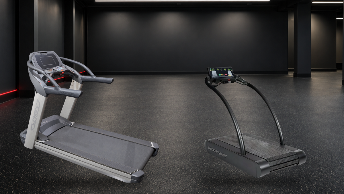 Cybex 770T and Woodway remanufactured commercial treadmills in a cool charcoal cardio bay with soft overhead LEDs