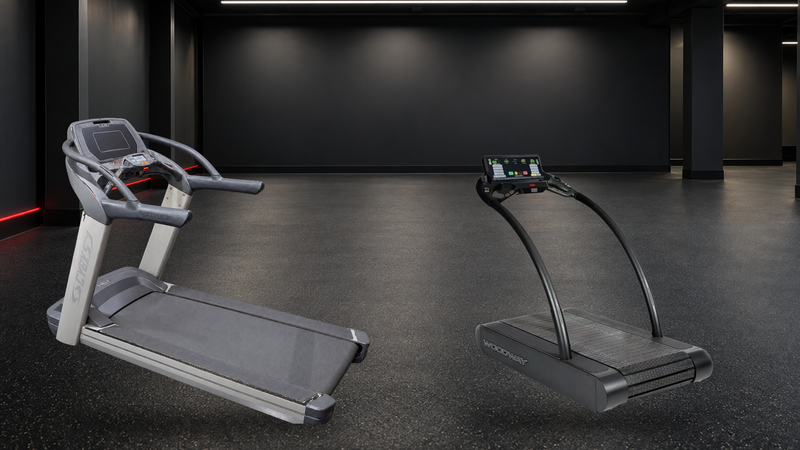 Cybex 770T and Woodway remanufactured commercial treadmills in a cool charcoal cardio bay with soft overhead LEDs